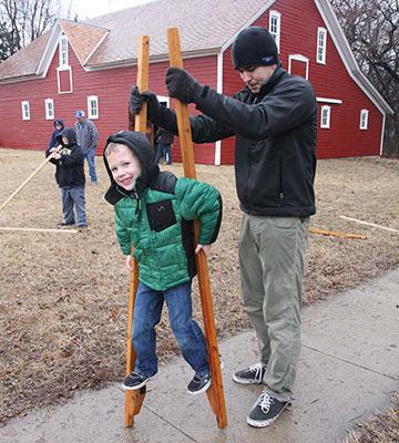 Trying out stilts at Kauffman Museum's Kansas Day celebration