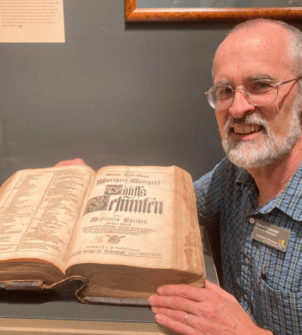 Dave Kreider with a copy of the Martyrs Mirror that he chose for the current Kauffman Museum special exhibit