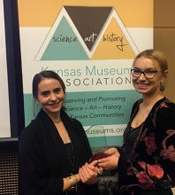 Elizabeth Friesen and Emma Girton with the KMA Award of Excellence for Kauffman Museum.
