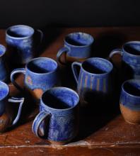 A collection of blue ceramic cups made by Edel Miller